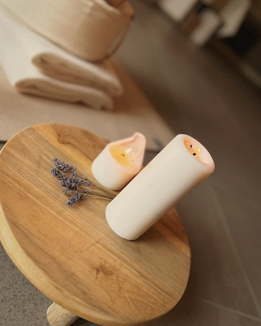 Kerze und Lavendel auf einem Holzhocker im Retreat-Raum