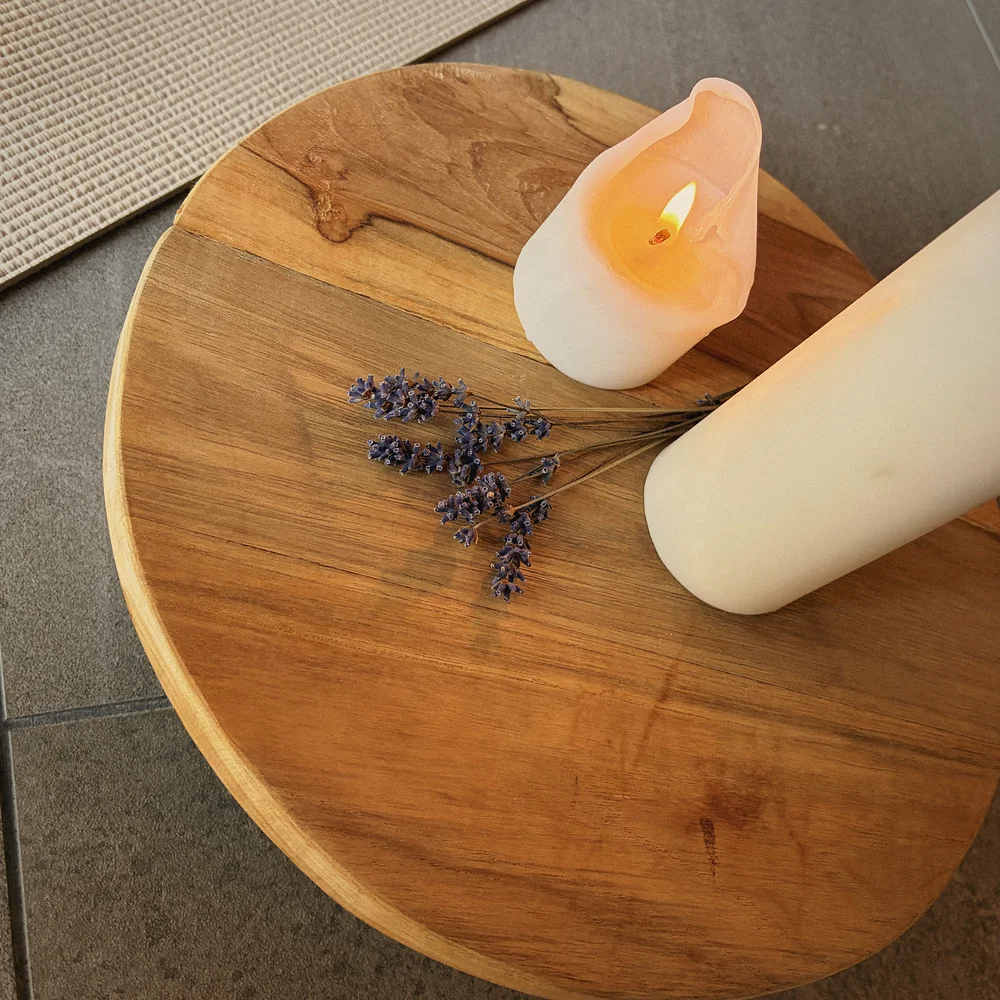 Kerzen und Lavendel auf einem Holzhocker